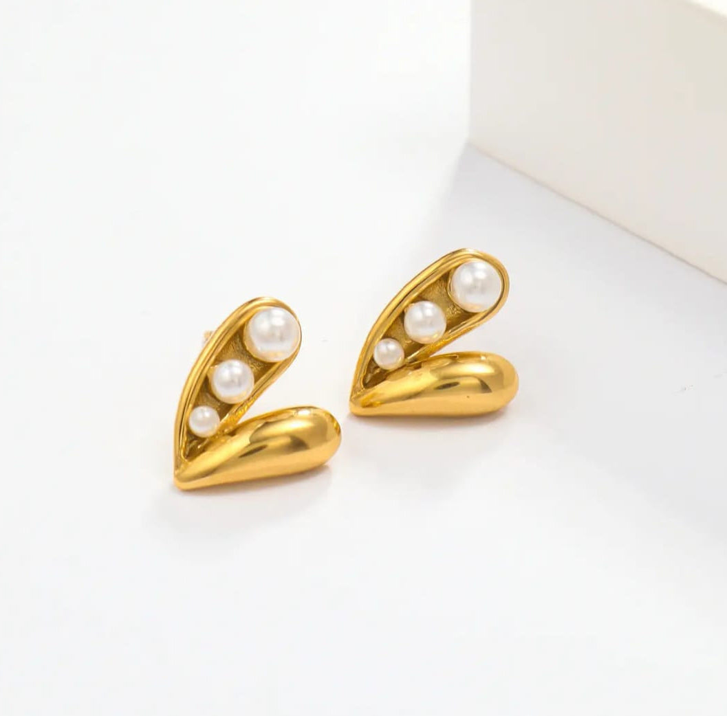 Gold earrings with pearl stones on a white background